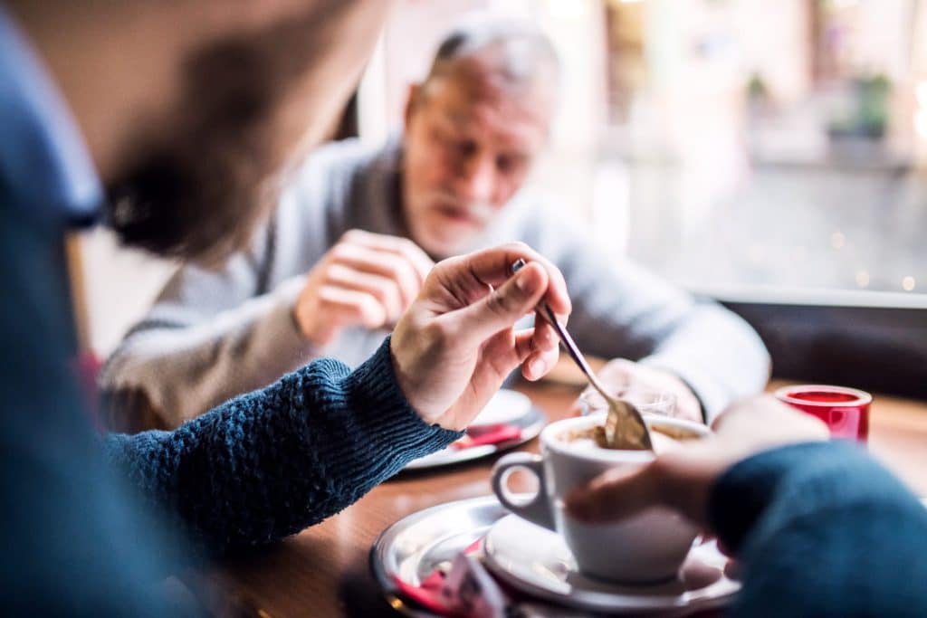 senior-father-and-his-young-son-in-a-cafe-P7XFLH2