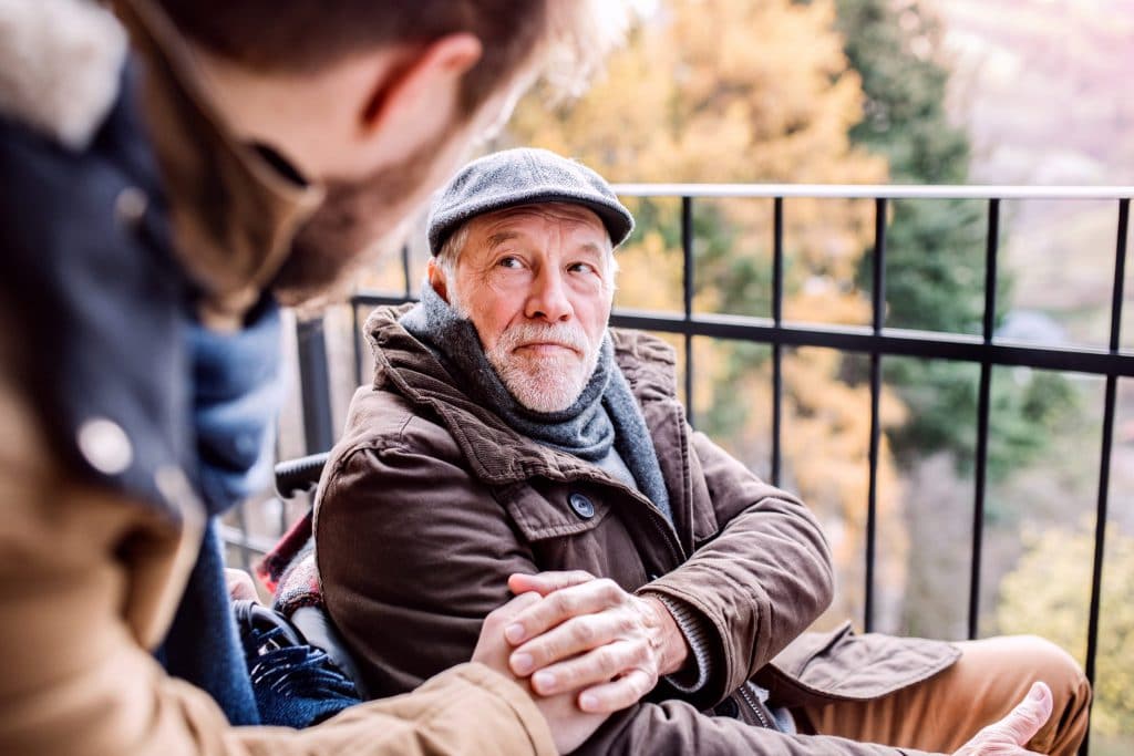 senior-father-in-wheelchair-and-young-son-on-a-PDUJQ5W